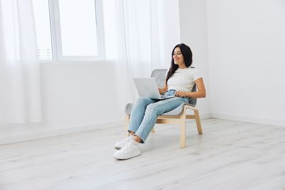 Young woman sitting on sofa at home