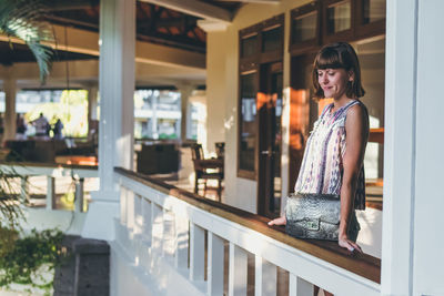 Portrait of young woman standing at home