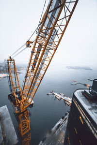 Crane in city against sky