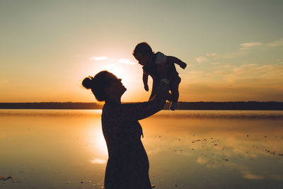 Mother with son enjoying sunset on the beach