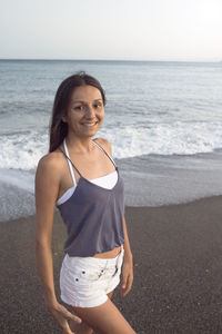 Portrait of smiling woman standing on beach