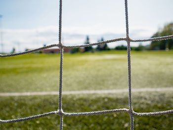 Goalpost net detail with green grass blur in background sports concepts