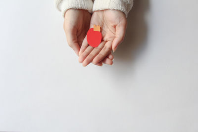 Cropped hand of woman holding toy against white background