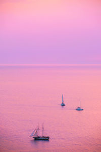 Sailboat sailing on sea against sky during sunset