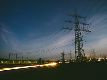 Low angle view of illuminated electricity pylon at night