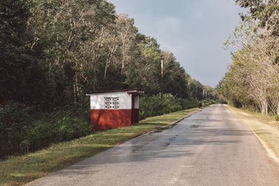 Road amidst trees against sky