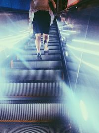 Woman standing on escalator