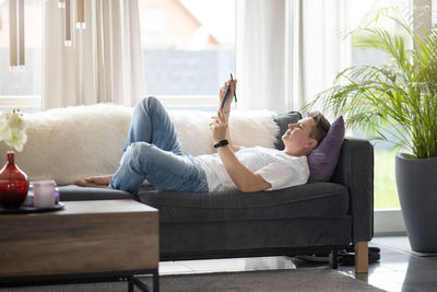 A woman is sitting on the couch and working on the laptop