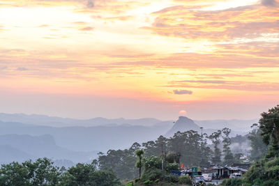 Scenic view of mountains against orange sky