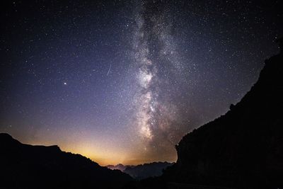 Low angle view of silhouette mountain against sky at night