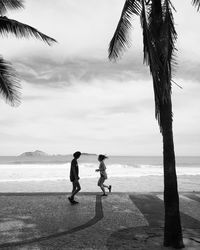 People at beach against sky