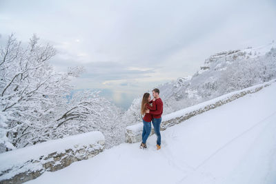 Man standing on snowcapped mountain against sky