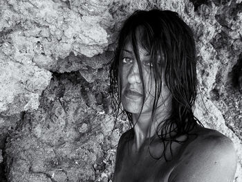 Close-up portrait of woman against rock