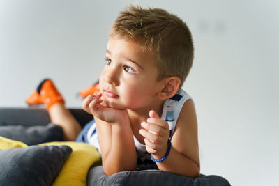 Portrait of boy sitting on sofa