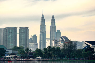 Skyscrapers in city against cloudy sky