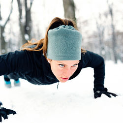 Woman doing push ups on snowy field
