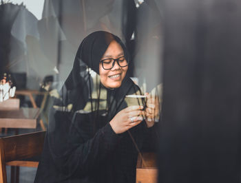 Smiling young woman drinking glass