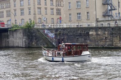 Boat sailing on river in city