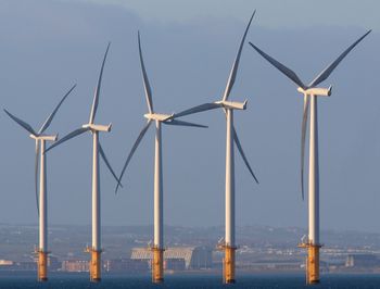 Wind turbines against sky