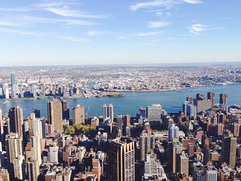 High angle view of city by sea against sky