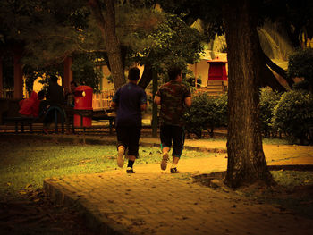 Rear view of two people walking in city