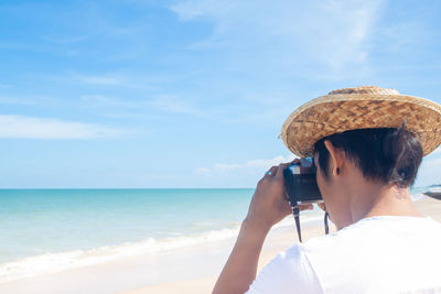 Rear view of person photographing sea