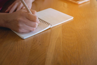 Midsection of man using mobile phone on table