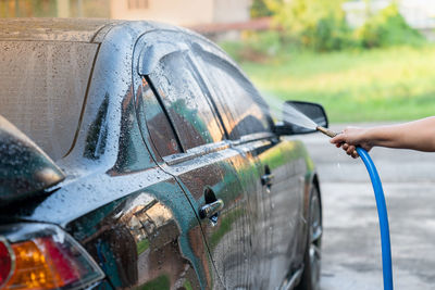 Manual car wash with pressurized water on car wash outside. spray water cleanning.