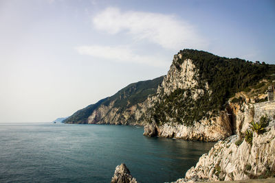 Scenic view of sea by mountains against sky