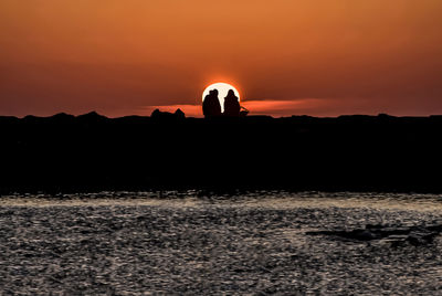 Silhouette man against orange sky during sunset