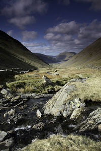 Stream flowing at honister pass against sky