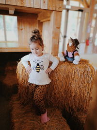 Girl dancing on hay bale at home
