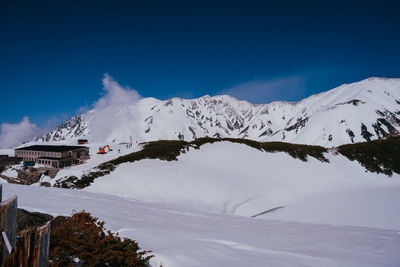 Scenic view of snowcapped mountains against blue sky