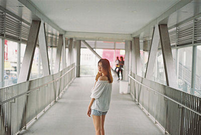 Rear view of woman standing on railing