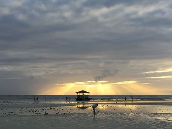 Scenic view of beach against dramatic sky