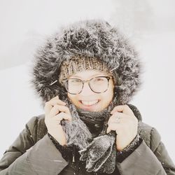 Portrait of smiling woman with snow covered hat during winter