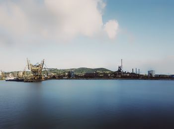 Commercial dock by sea against sky