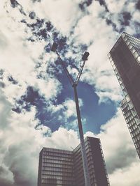 Low angle view of modern building against cloudy sky