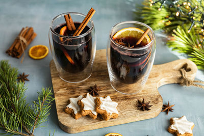 Hot winter drink mulled wine with spices and fresh orange slices in new year's decorations.