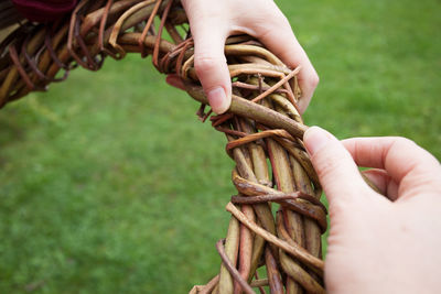 Cropped hands of woman making basket