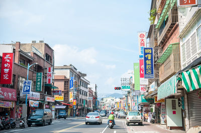 View of city street and buildings against sky