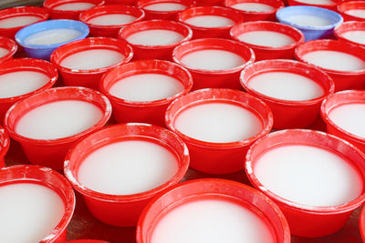 Full frame shot of white liquid in red containers