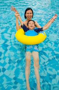 Smiling mother and son in swimming pool