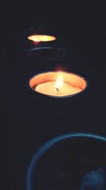 Close-up of lit candle in dark room