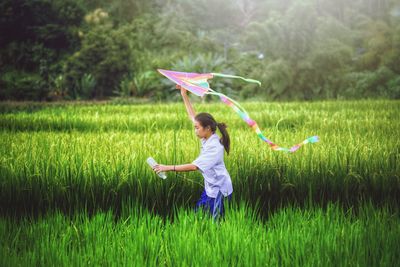Full length of girl holding umbrella on field
