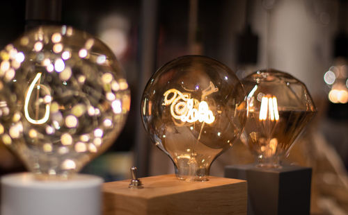 Close-up of illuminated candles on glass table
