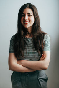 Portrait of a smiling young woman against white background