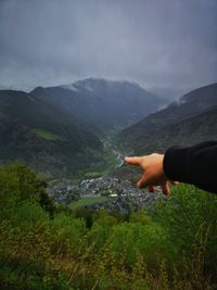 Man hand on mountain against sky