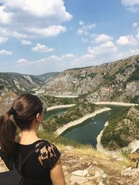 Beautiful woman standing by lake against sky