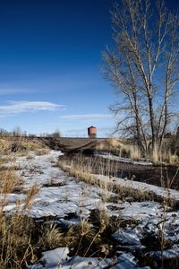 Gravel road heads towards historical wooden water tower 